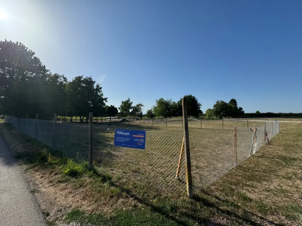 Der eingezäunte Hundeplatz der Hundeschule Fellcoach in Endingen unter blauem Himmel.
